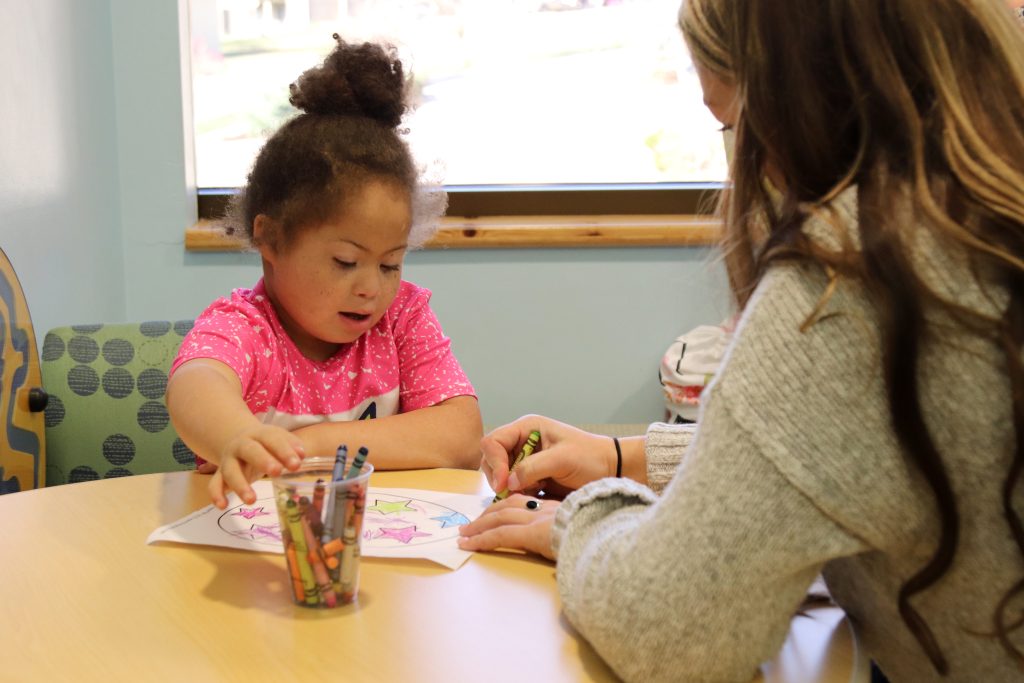 Patient and clinician drawing on a coloring page together